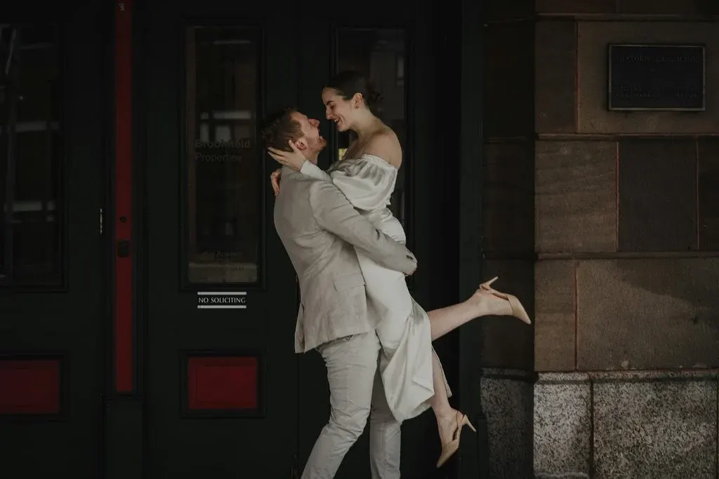 Newlyweds embracing outside a building